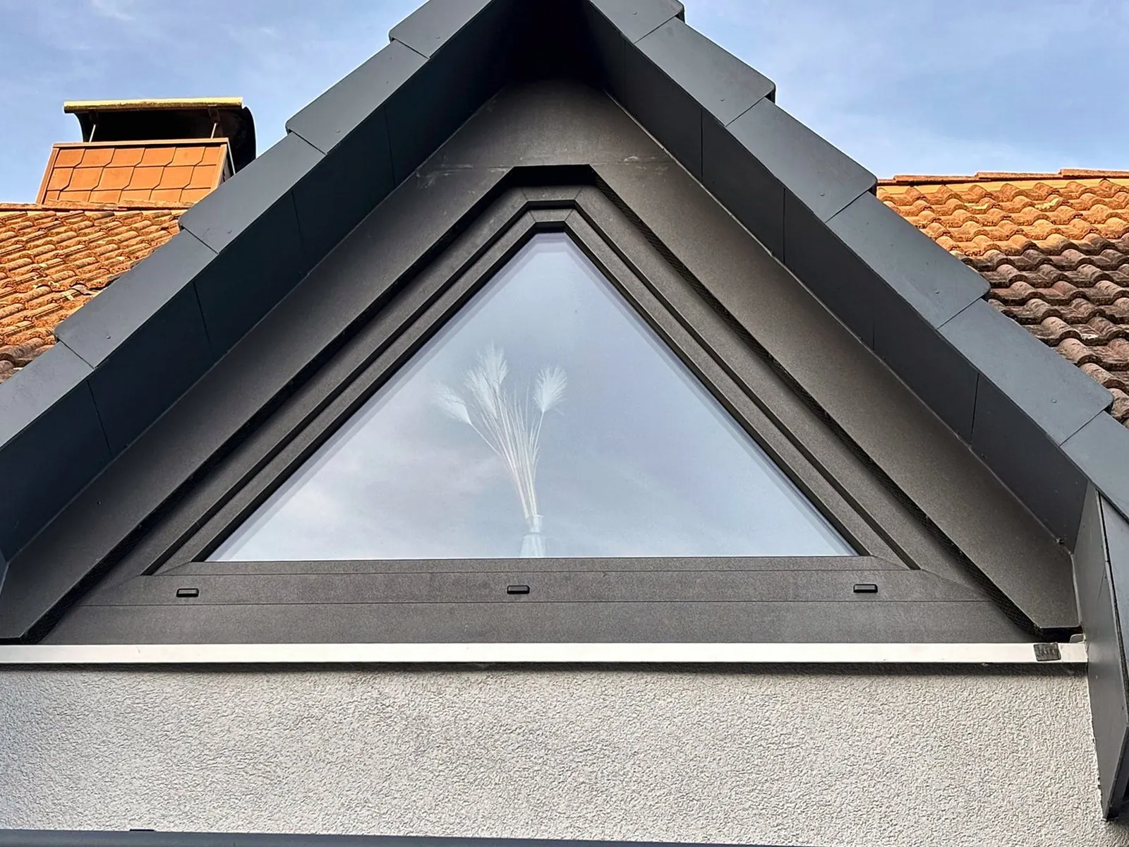 Dreieckiges Giebelfenster in Anthrazit unter dem Dachfirst