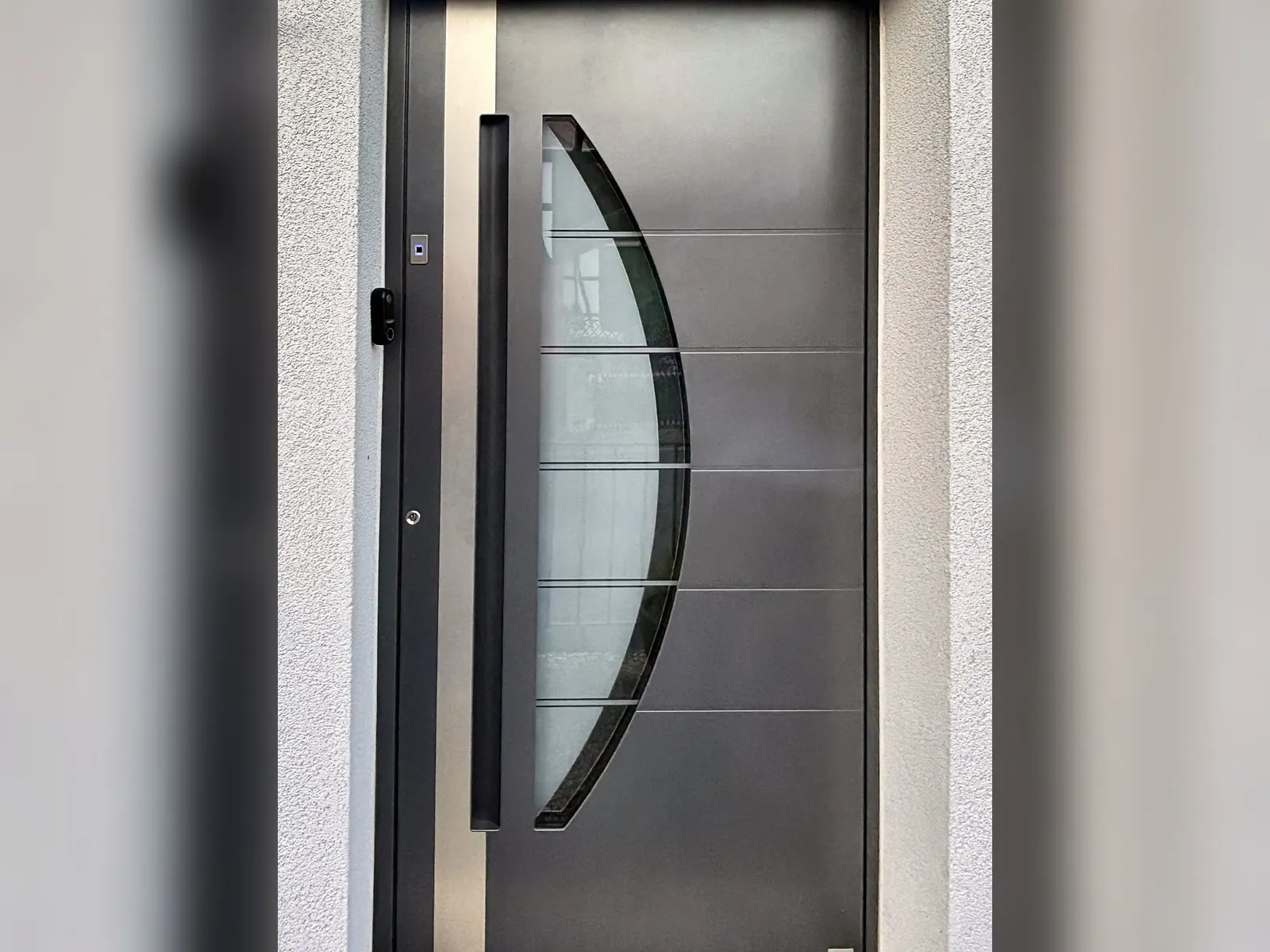 Haustür in Anthrazit mit bogenförmigem Glaseinsatz und Edelstahl-Stoßgriff