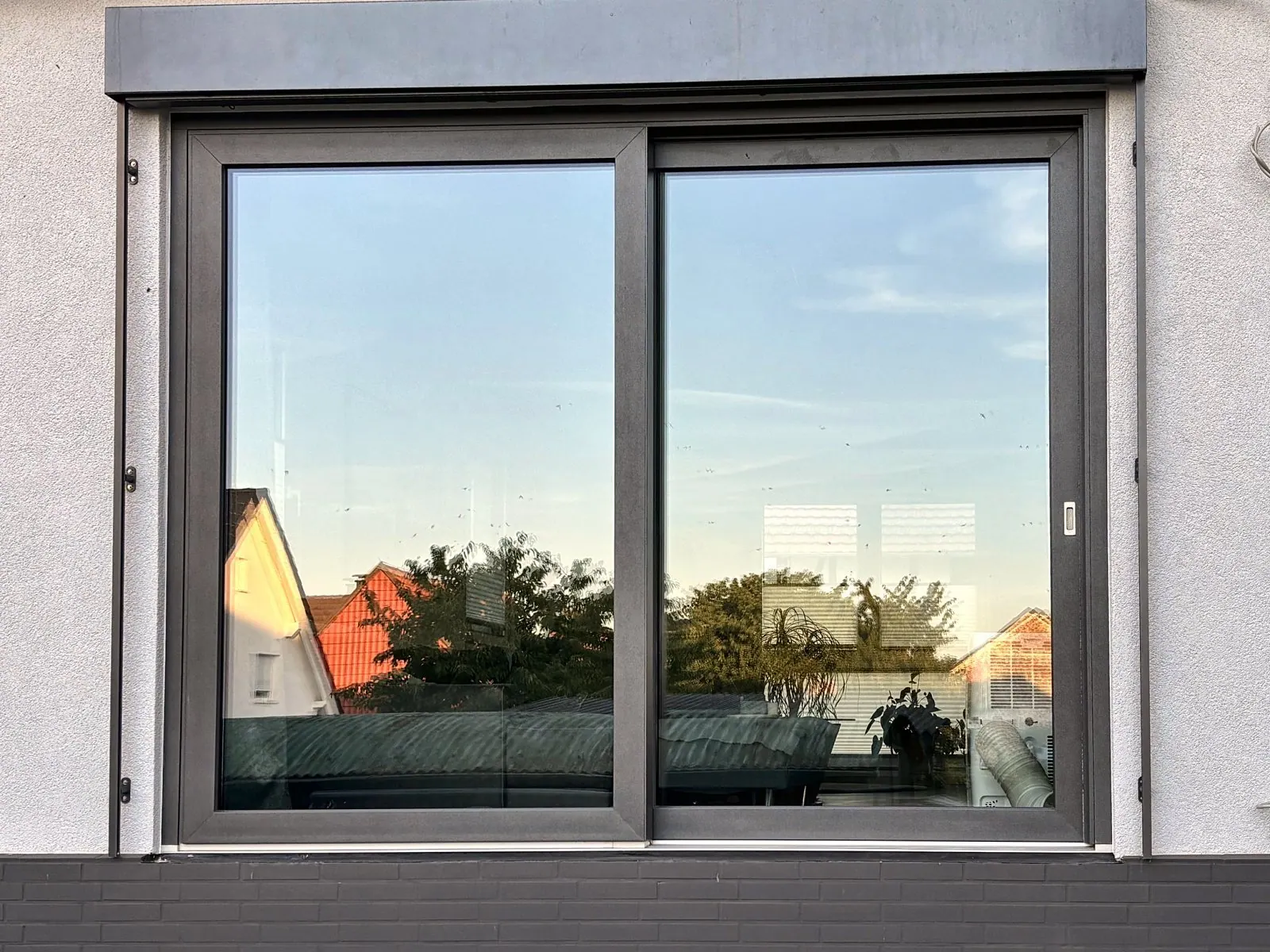 Großes zweiteiliges Fensterelement in Anthrazit mit Raffstore-Kasten